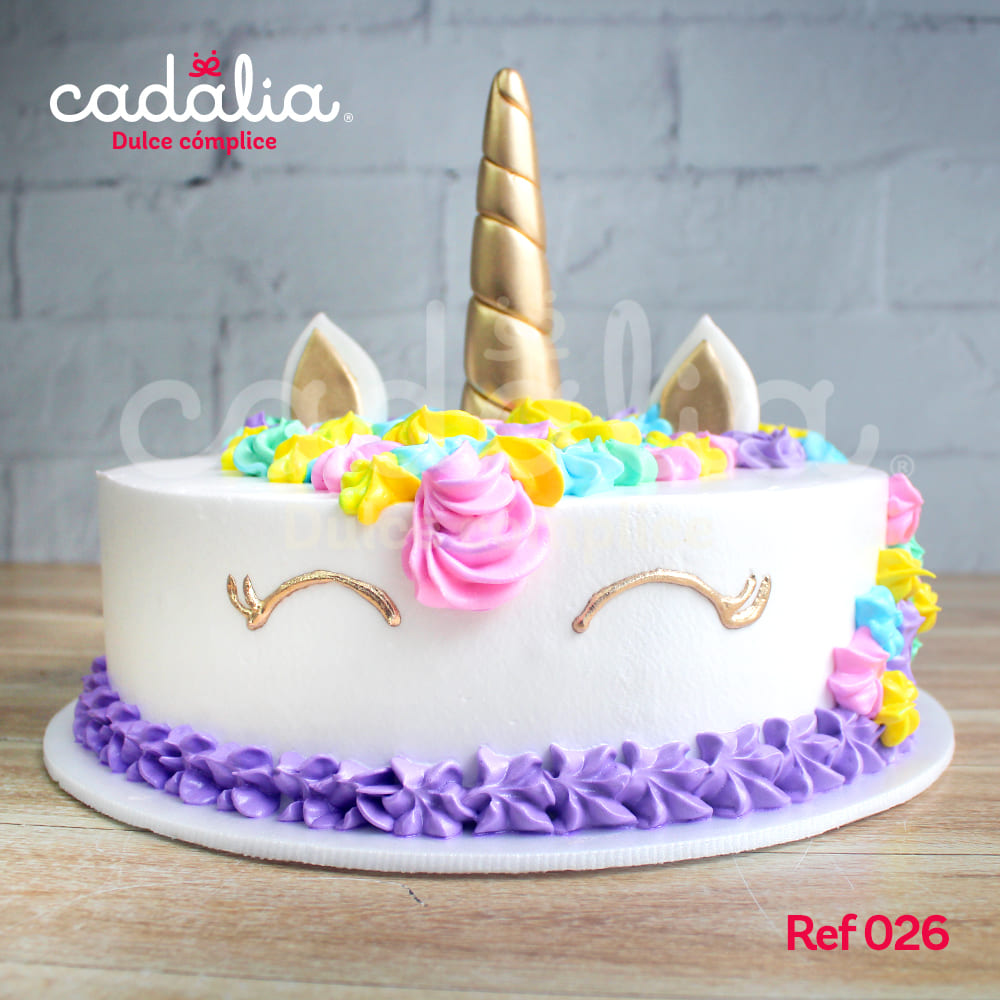 Torta personalizada Unicornio Cadalia, con flores color pastel en crema y cuerno y ojos dorados